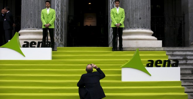 Un hombre toma una foto en la entrada del edificio de la Bolsa de Madrid el día del estreno en el mercado de AENA, en febrero de 2015.  REUTERS/Susana Vera