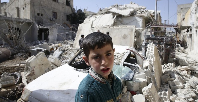 Un niño observa los daños de uno de los bombardeos, ayer, en Damasco. REUTERS/ Bassam Khabieh