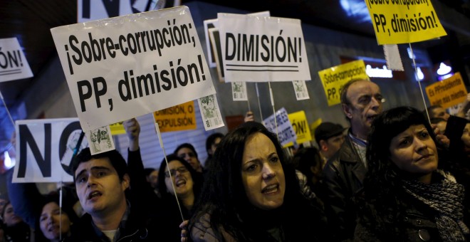 Manifestantes protestando contra la corrupción en el PP, en una concentración frente a la sede nacional del partido, en la madrileña calle de Génova, en  febrero de 2014. REUTERS/Susana Vera