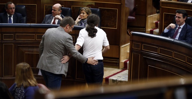 El líder de Podemos, Pablo Iglesias, y el de En Comú Podemo, Xavier Domenech, se saludan al volver a sus asientos.- REUTERS/Andrea Comas