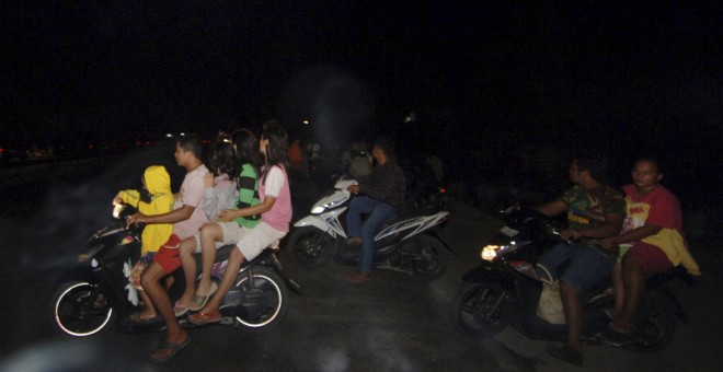 Varios residentes de la ciudad de Padang, en Sumatra Occidental, escapan con sus motocicletas ante la alerta de tsunami. REUTERS/Iggoy el Fitra