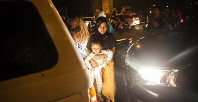 Residentes de Padang, la capital de Sumatra Occidente, permanecen en la calle tras el aviso de tsunami. EFE/Zulkifli