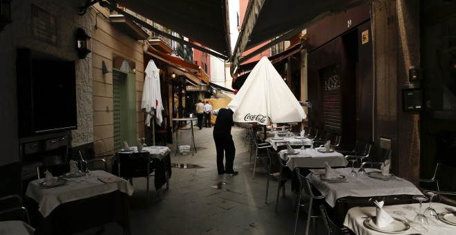 Un camarero prepara las mesas en la terraza de un bar en el centro de Sevilla. REUTERS