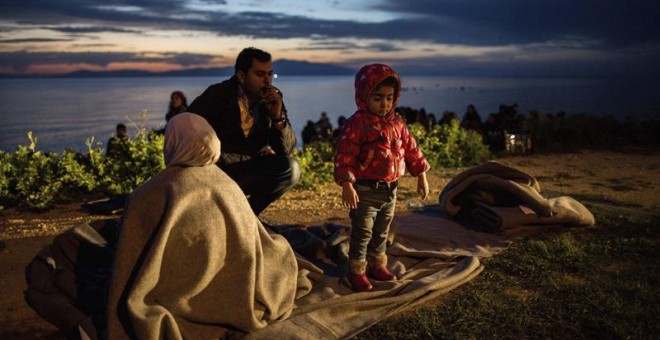 Una familia de refugiados descansa tras llegar a la isla de Lesbos tras cruzar el mar desde Turquía en el puerto de Mytilene (Grecia) hoy, 9 de marzo de 2016. EFE/Kay Nietfeld