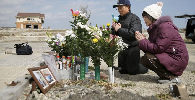 Tsuyoshi Yoshida y su esposa Seiko rezar por su hija Miki, que murió opr el tsunami de mazo de 2011 en la ciudad de Namie, en la prefectura de Fukushima. REUTERS/Kyodo