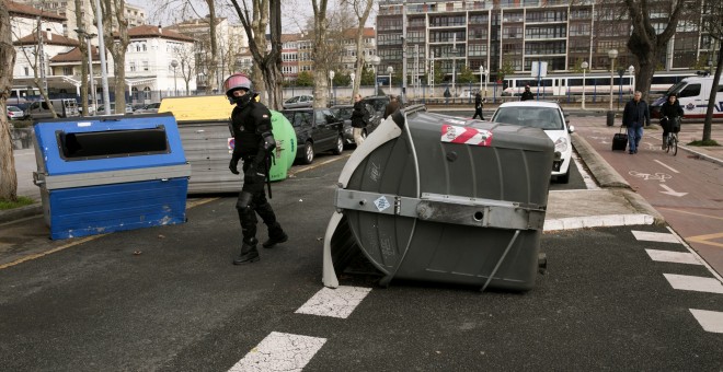 Agentes de la ertzaintza retiran una barricada colocada por grupos de estudiantes que han cortado el tráfico durante los incidentes que se han registrado hoy en el campus alavés de la Universidad del País Vasco (UPV/EHU) en Vitoria, en donde ha tenido lug