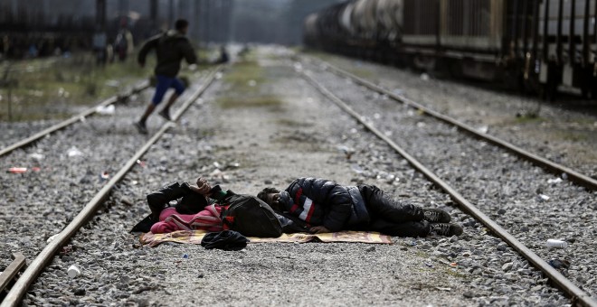 Dos refugiados duermen en las vías del tren en un campamento improvisado en la frontera entre Grecia y Macedonia, cerca de la localidad de Idomeni. REUTERS/Alkis Konstantinidis