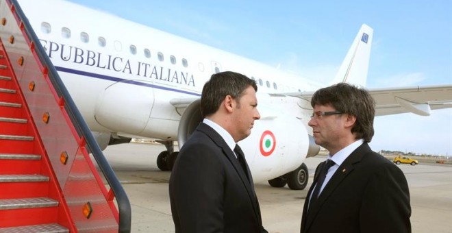 Llegada del primer ministro italiano, Matteo Renzi (i), al aeropuerto de Reus, donde es recibido por el presidente de la Generalitat, Carles Puigdemont (d).- EFE/Xavi Jurio