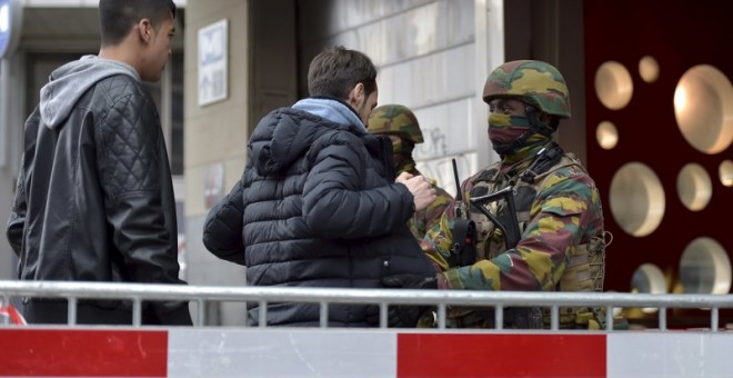 Militares belga realizan cacheos a la entrada de una estación de metro en Bruselas. - REUTERS