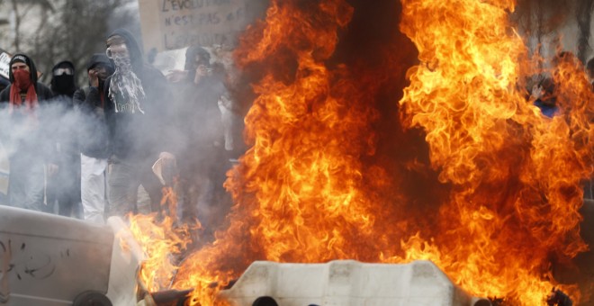 Manifestantes tras una barricada de contenedores ardiendo durante una protesta contra la reforma laboral de Frnacia en Nantes.-  REUTERS / Stephane Mahe