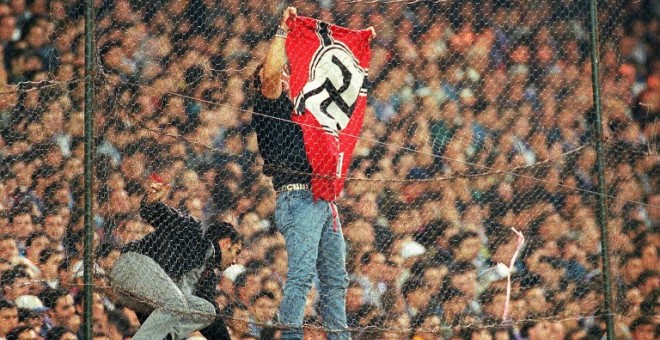 Un hombre coloca una bandera nazi en el Santiago Bernabéu durante un Real Madrid-Barcelona de 1997. - AFP