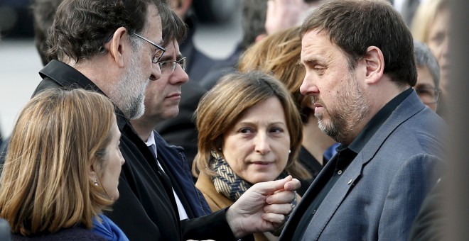 El presidente del Gobierno en funciones, Mariano Rajoy, conversa con el vicepresident y conseller de Finanzas, Oriol Junqueras, en presencia de president de la Generalitat, Carles Puigdemont, tras el acto de recuerdo de las víctimas del accidente de Germa