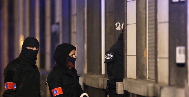 Policías belgas enmascarados aseguran la entrada a un edificio en el barrio de Schaerbeek durante las operaciones tras los ataques con bombas del martes en Bruselas, Bélgica.- REUTERS / Christian Hartmann