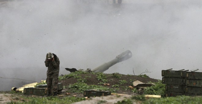 Un militar armenio del ejército de autodefensa de Nagorno-Karabaj en una pieza de artillería disparando hacia las fuerzas azeríes en la ciudad de Martakert en la región de Nagorno-Karabaj. REUTERS / Vahram Baghdasaryan