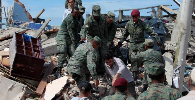 Autoridades y pobladores buscan sobrevivientes entre los escombros en la localidad de Pedernales (Ecuador), hoy domingo 17 de abril de 2016, después del terremoto de 7,8 grados en la escala de Richter registrado el sábado en la costa norte de Ecuador. El
