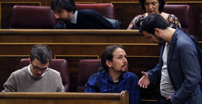 El diputado de IU, Alberto Garzón, conversa con el líder de Podemos, Pablo Iglesias, durante el pleno del Congreso. EFE/Kiko Huesca