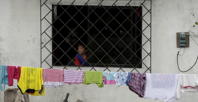 Un niño mira a través de una ventana en su casa dañada en Pedernales. REUTERS/Henry Romero