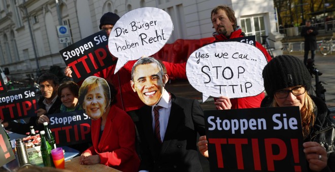 Manifestantes con caretas de Angela Merkel y de Barack Obama protesan en Hannover contra el TTIP. REUTERS/Kai Pfaffenbach