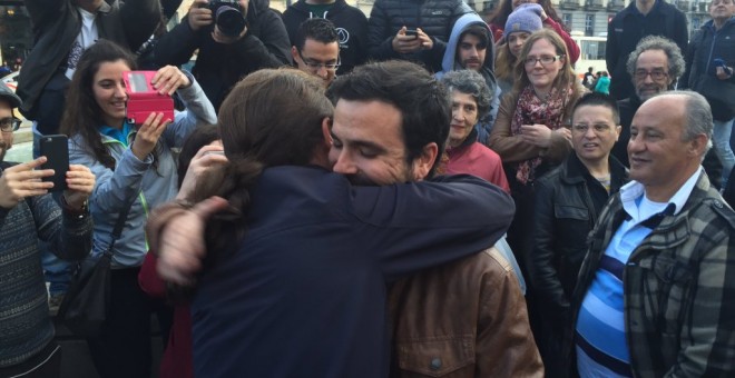Alberto Garzón, líder de Izquierda Unida, y Pablo Iglesias, secretario general de Podemos, se abrazan en la Puerta del Sol de Madrid, para rubricar su acuerdo electoral. PODEMOS