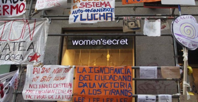 Un escaparate junto a la Puerta del Sol rodeado de carteles reivindicativos al fondo. REUTERS /Sergio Pérez