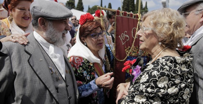 La alcaldesa de Madrid, Manuela Carmena, conversa con unos chulapos durante la romería con motivo de la festividad de San Isidro, patrón de la ciudad, en la Pradera de San Isidro. EFE/Emilio Naranjo