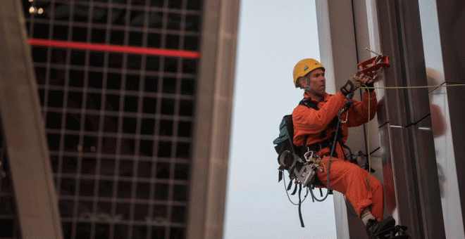 Un activista de Greenpeace colgado de una de las torres Kio en una acción contra el TTIP este martes en Madrid. GREENPEACE