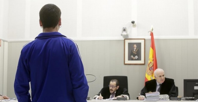 Jon Vicente Egurcegui (de espaldas) declarando en la Audiencia Nacional por publicar de forma continuada en redes sociales comentarios en los que ensalzaba a la banda terrorista ETA. EFE/Zipi