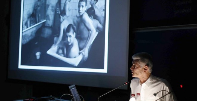 El fotoperiodista James Nachtwey mostrando una de sus fotos a un auditorio.