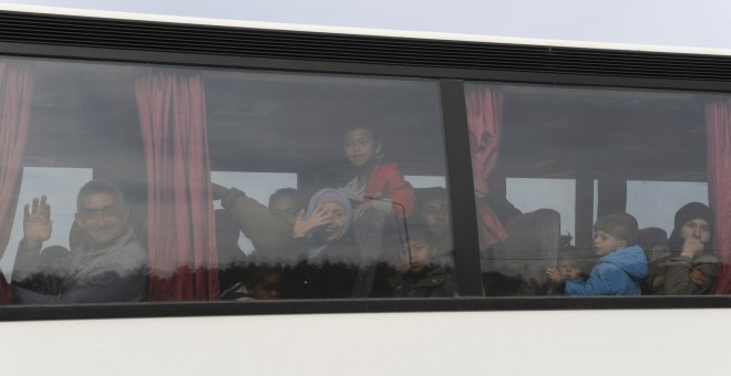 Un autobús abandonando el campamento de Idomeni rumbo a alguno de los nuevos centros oficiales abiertos en el norte de Grecia./ REUTERS