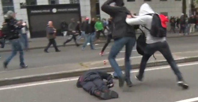 Un policía belga, inconsciente tras recibir un golpe en la cabeza durante la manifestación en Bruselas.