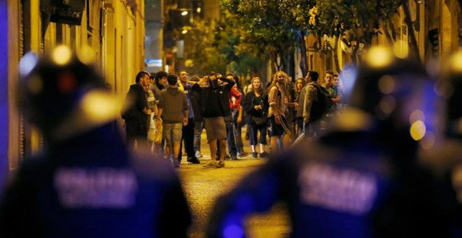 Miembros de los cuerpos antidisturbios ante varios manifestantes, a la entrada del 'banco expropiado', una antigua sucursal bancaria ocupada en 2011, tras la manifestación en protesta por su desalojo. EFE/Alejandro García.