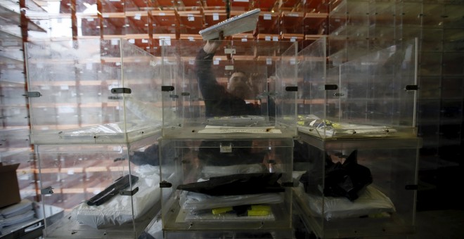 Un operario prepara las urnas para la jornada electoral del 20-D. REUTERS
