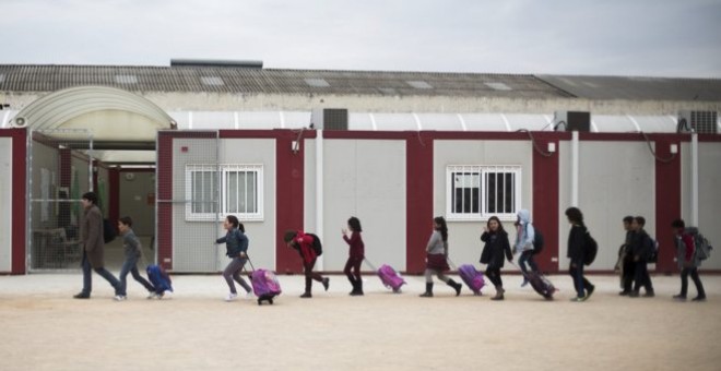 Alumnos del colegio público Ciudad de Cremona salen de los barracones al finalizar las clases. BIEL ALIÑO. EFE Valencia