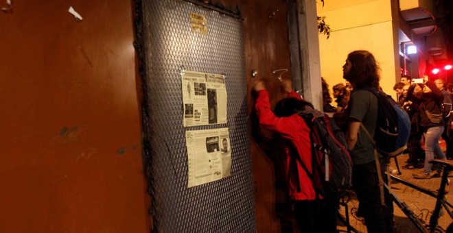 Unos vecinos golpean con cucharas las puertas del banco expropiado. EFE/Quique García