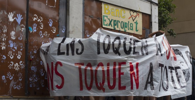 Simpatizantes del movimiento por la ocupación del 'Banc Expropiat' se colocan frente a la puerta del local. EFE/Quique García