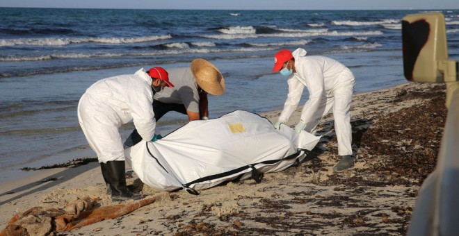 Trabajadores de la Cruz Roja de Libia recogen cadáveres en una playa de Libia. REUTERS