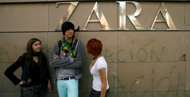 Unos jóvenes conversan en el exterior de una tienda de Zara en Sevilla. REUTERS/Marcelo del Pozo