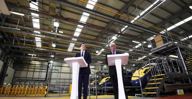 El ministro de Finanzas británicoa, George Osborne, a la izquierda, junto a uno de sus antecesores durante un acto en una fábrica. / REUTERS