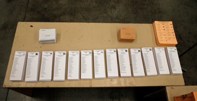 Mesa con papeletas de las diversas formaciones políticas  en un colegio electoral las pasadas elecciones del 20-D.- REUTERS