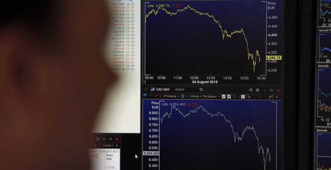 Un 'broker' francés observa en las pantallas las marcha del mercado. REUTERS