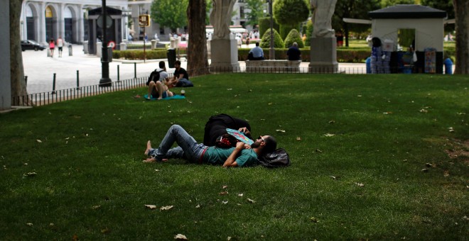Una pareja tumbnada a la sombra en el centro de Madrid. REUTERS/Juan Medina