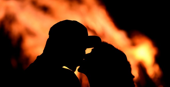 Una pareja se besa delante de una hoguera durante la tradicional noche de San Juan en Gijó. REUTERS / Eloy Alonso