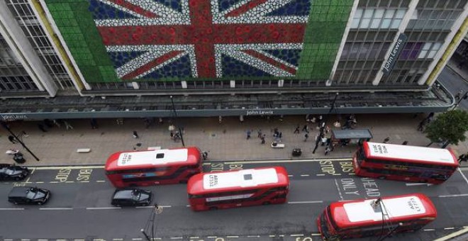 Peatones caminan por Oxford Street donde se colocó una bandera británica en la fachada de unos grandes almacenes en Londres durante la jornada de referéndum por el Brexit. EFE