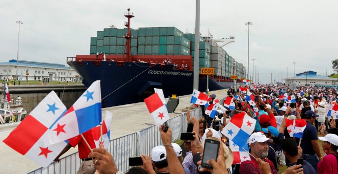 Personas celebrando la inauguración del Canal de Panamá con banderas del país. REUTERS/Carlos Jasso