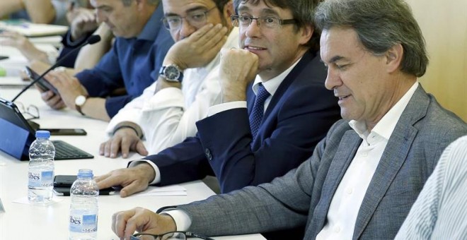 El presidente de CDC, Artur Mas, junto al president de la Generalitat, Carles Puigemont, durante la reunión que mantuvo el comité ejeutivo de la formación para valorar los resultados de las elecciones generales. EFE/Andreu Dalmau