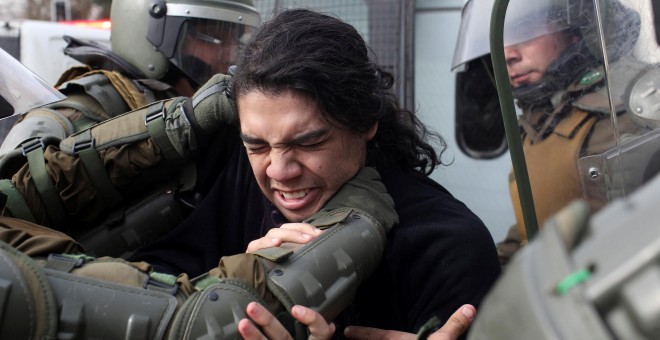 Varios agentes detienen a un estudiante en Santiago de Chile. - REUTERS