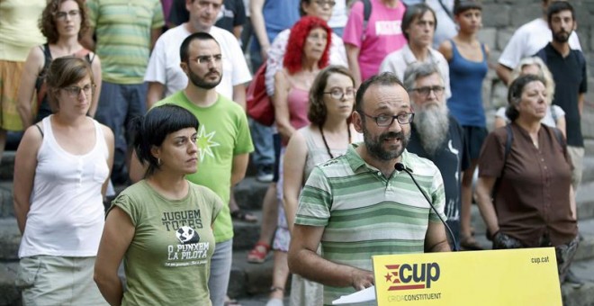 Los diputados Anna Gabriel (i) y Benet Salellas (c) de la CUP, junto a otros representantes de la formación, han pedido hoy, en la plaza del Rey de Barcelona, al presidente de la Generalitat Carles Puigdemont, que convoque una cumbre de partidos favorabl