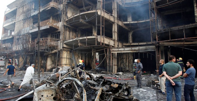 Varias personas cargan con una víctima del atentado en Bagdad que se ha cobrado al meno 80 víctimas.- REUTERS