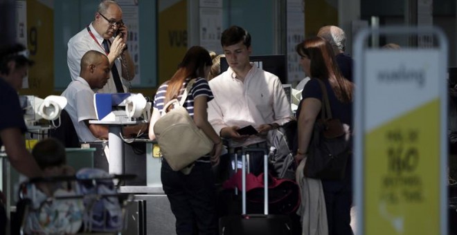 Personal de facturación de Vueling atiende a los viajeros en el Aeropuerto de El Prat, después de que la aerolínea haya cancelado esta mañana una decena de vuelos con destino u origen Barcelona y que la mayoría de rutas acumulen retrasos, algunos de hasta
