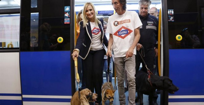 La presidenta de la Comunidad de Madrid, Cristina Cifuentes junto al presidente de El Refugio, Nacho Paunero, en el interior del metro con dos perritos rescatados del abandono. EFE